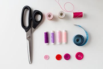 Image showing scissors, sewing buttons, threads and tape measure