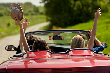 Image showing happy friends driving in cabriolet car at country