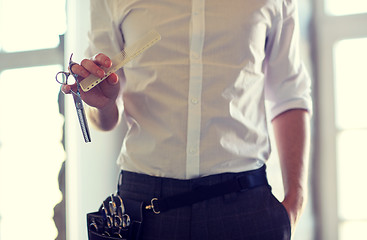 Image showing close up of male stylist with scissors at salon