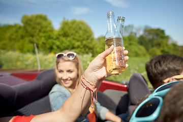 Image showing happy young women with drinks in convertible car