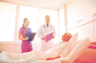 Image showing doctor and nurse visiting senior woman at hospital