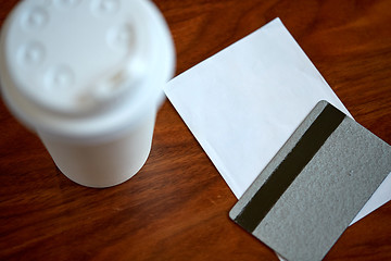 Image showing coffee in paper cup, bill and credit card on table