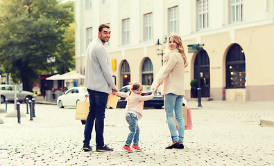 Image showing happy family with child and shopping bags in city