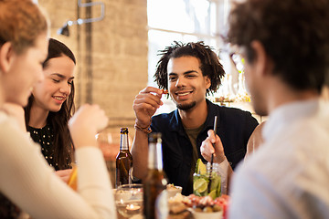 Image showing happy friends eating and drinking at bar or cafe