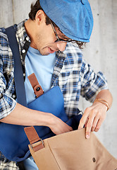 Image showing close up of hipster man looking into his bag