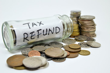 Image showing Tax refund lable in a glass jar with coins spilling out