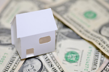 Image showing Miniature paper made house stand on  money