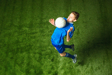 Image showing Young boy with soccer ball doing flying kick