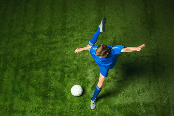 Image showing Young boy with soccer ball doing flying kick