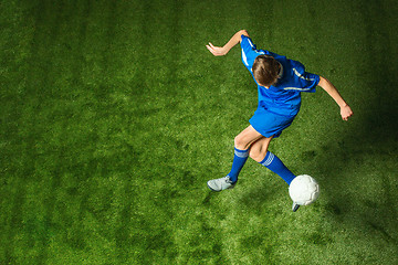 Image showing Young boy with soccer ball doing flying kick