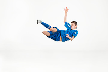 Image showing Young boy with soccer ball doing flying kick