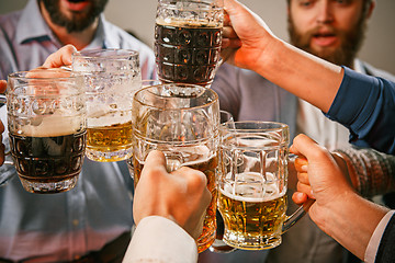 Image showing Group of friends enjoying evening drinks with beer