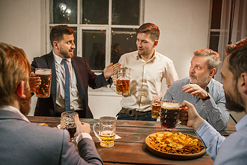 Image showing Group of friends enjoying evening drinks with beer