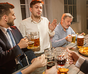 Image showing Group of friends enjoying evening drinks with beer