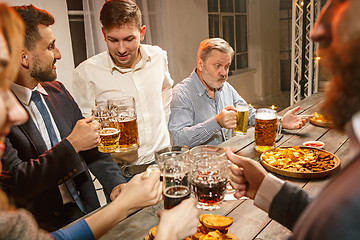 Image showing Group of friends enjoying evening drinks with beer