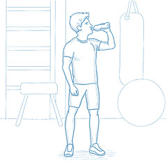 Image showing Sportive man drinking water in the gym.