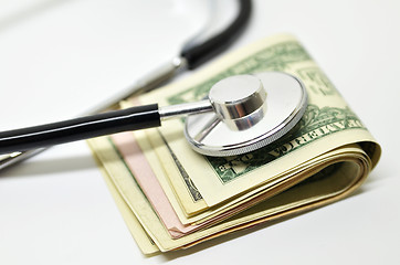 Image showing Stethoscope sitting on US dollar bills