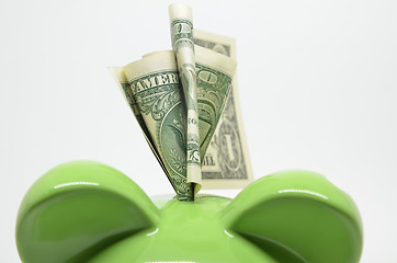 Image showing Green piggy bank with US dollar bills 