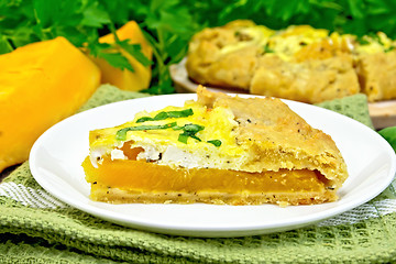 Image showing Pie of pumpkin and cheese in white plate on dark board