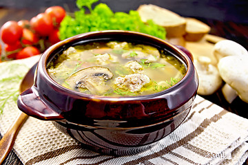 Image showing Soup with meatballs and mushrooms in pottery on napkin