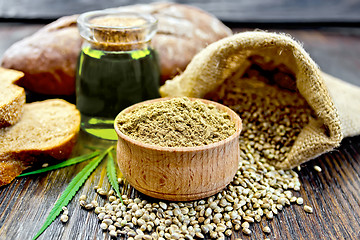 Image showing Flour hemp in bowl with bread and oil on dark board