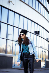 Image showing young pretty girl near business building walking