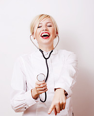 Image showing young pretty woman doctor with stethoscope emotional posing, pointing in camers, lifestyle people concept