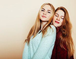 Image showing Two young girlfriends in winter sweaters indoors having fun. Lif