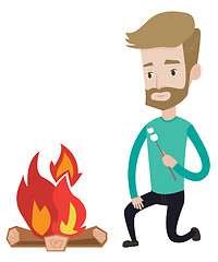 Image showing Man roasting marshmallow over campfire.