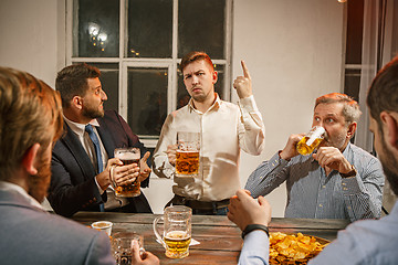 Image showing Group of friends enjoying evening drinks with beer