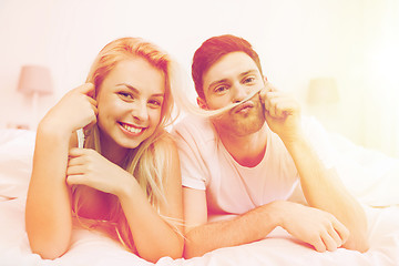 Image showing happy couple lying in bed at home