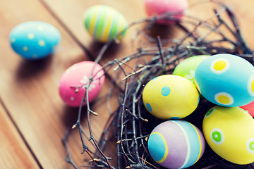 Image showing close up of colored easter eggs in nest on wood