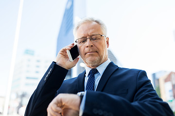 Image showing senior businessman calling on smartphone in city