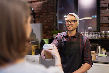 Image showing seller giving coffee cup to woman customer at cafe