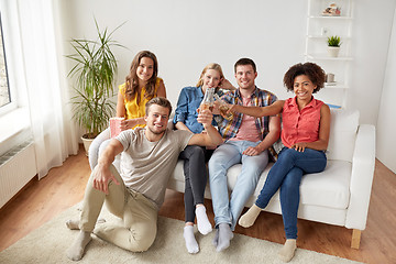 Image showing happy friends with popcorn and beer at home