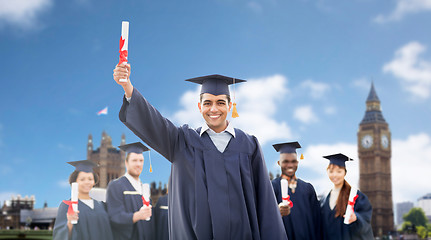 Image showing happy students in mortarboards with diplomas