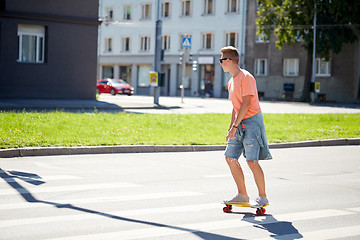 Image showing teenage boy on skateboard crossing city crosswalk