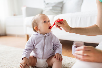 Image showing mother with spoon feeding little baby at home