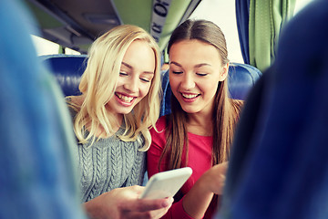 Image showing happy young women in travel bus with smartphone