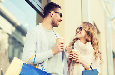 Image showing happy couple with shopping bags and coffee in city