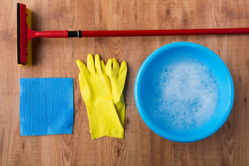 Image showing basin with cleaning stuff on wooden background