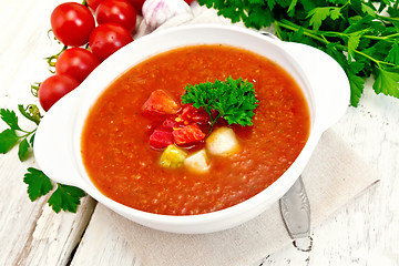 Image showing Soup tomato in white bowl with vegetables and parsley on board