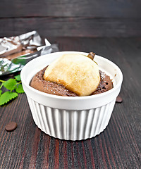 Image showing Cake with chocolate and pear in white bowl on dark board