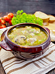 Image showing Soup with meatballs and mushrooms in clay bowl on napkin