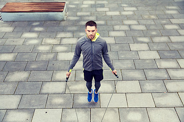 Image showing man exercising with jump-rope outdoors