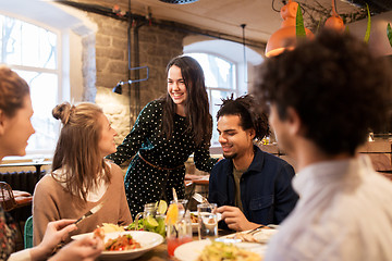 Image showing happy friends eating and drinking at restaurant