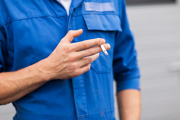 Image showing close up of auto mechanic smoking cigarette