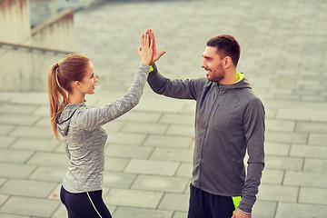 Image showing happy couple giving high five outdoors