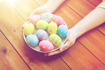 Image showing close up of woman hands with colored easter eggs