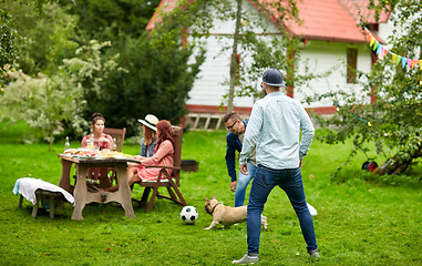 Image showing friends playing football with dog at summer garden